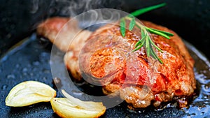 Grilled Wagyu fillet steak and rosemary on hot iron plate. Prime beef fry on electric roaster