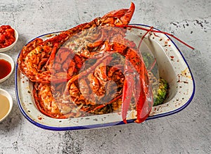 Grilled whole boston lobster with fried rice, grilled corn and broccoli served in isolated on grey background top view of