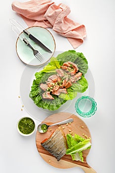 Grilled wild salmon and lettuce dish with green pesto, top view, vertical banner
