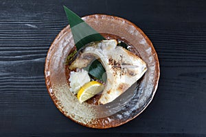 Grilled yellowtail collar on a dining table