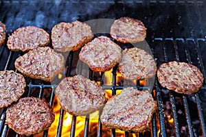 Grilling beef meat barbecue burgers on the barbecue grill using a fire flame