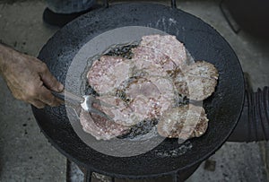 Grilling beefburgers on hot oil