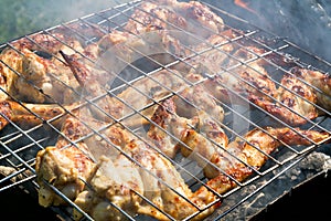 Grilling chicken on a barbecue in smoke