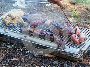 slow grilling chorizo sausages , chicken quarters, skirt and flank muscle steaks argentinian cuts photo