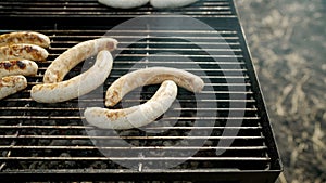 Grilling different kinds of sausages, dry and fresh meat on an open barbeque. Kupaty is grilled in the open air.