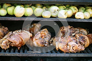 Grilling food. The meat is barbecued with coals. Pork knuckle with apples on the barbecue.