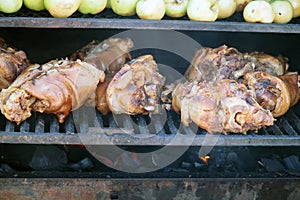 Grilling food. The meat is barbecued with coals. Pork knuckle with apples on the barbecue.