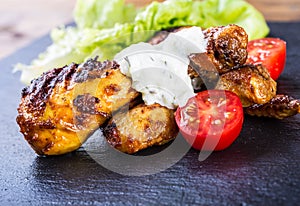 Grilling. Grilled chicken. Grilled chicken legs. Grilled chicken legs, lettuce and cherry tomatoes. Traditional cuisine. photo
