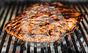 Grilling marinated angus beef flank steak on hot coals barbecue grill