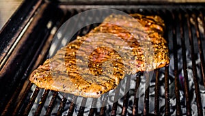 Grilling marinated beef flank steak on hot coals barbecue grill
