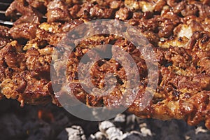 Grilling marinated shashlik on a grill.