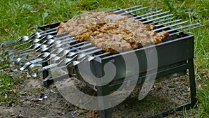 Grilling marinated shashlik on a grill. Shashlik is a form of Shish kebab popular in Eastern, Central Europe and other