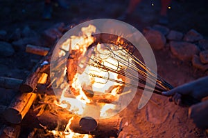 Grilling meat on a fire.