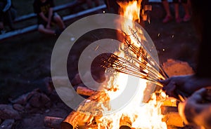 Grilling meat on a fire.