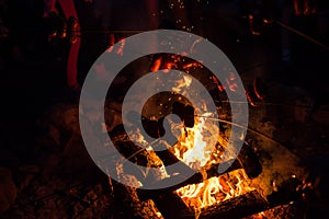 Grilling meat on a fire.