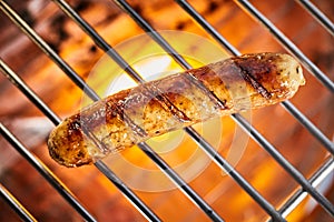 Grilling one sausage on barbecue grill