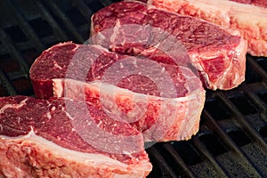 grilling raw steaks on gas grill and shot with selective focus