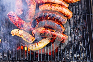 Grilling sausages on barbecue grill. Delicious sausages on charcoal grill