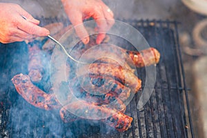 Grilling sausages on barbecue grill. Delicious sausages on charcoal grill