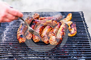 Grilling sausages on barbecue grill. Delicious sausages on charcoal grill