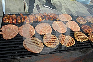 Grilling sausages, burgers, pork steak on barbecues gas grill for party. Hot dogs,sausages and hamburgers on a barbeque, bbq. Smok