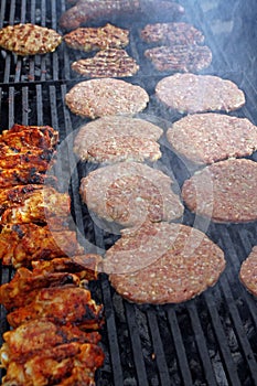 Grilling sausages, burgers, pork steak on barbecues gas grill for party. Hot dogs,sausages and hamburgers on a barbeque, bbq. Smok