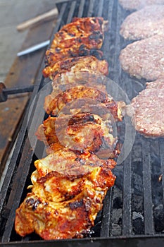 Grilling sausages, burgers, pork steak on barbecues gas grill for party. Hot dogs,sausages and hamburgers on a barbeque, bbq. Smok