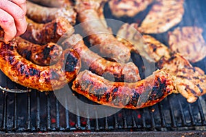 Grilling sausages and pork chops on barbecue grill. BBQ in the garden