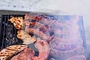 Grilling sausages and pork chops on barbecue grill. BBQ in the garden