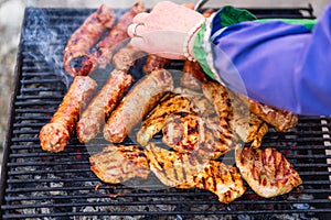 Grilling sausages and pork chops on barbecue grill. BBQ in the garden