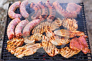 Grilling sausages and pork chops on barbecue grill. BBQ in the garden