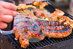 Grilling sausages and pork chops on barbecue grill. BBQ in the garden