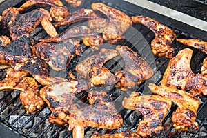 Grilling spicy chicken wings on barbecue grill