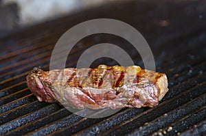 grilling steaks on flaming grill