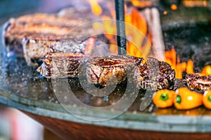 Grilling steaks on flaming grill