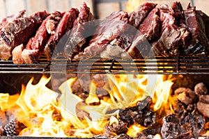 Grilling steaks on flaming grill and shot with selective focus