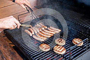 Grilling at summer weekend. Fresh meat preparing on grill.Man hand at a barbecue grill preparing meat for a garden party