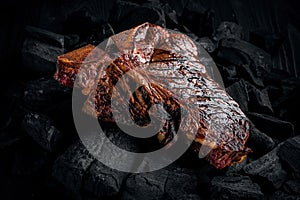 Grilling a tasty tender marinated t-bone steak on a coals.