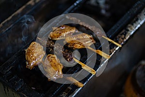 Grilling yakitori (Japanese style skewered chicken)