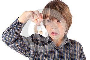Grimacing boy showing a hearing aid.