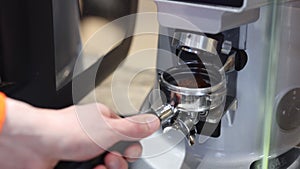 Grind coffee in machine Spbi. Barista man push button and make ground bean powder pouring
