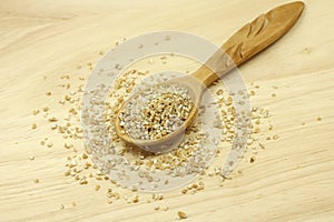 Grind wheat in a wooden spoon