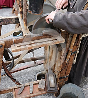 Grinder with hands sharpen a blade of a knife