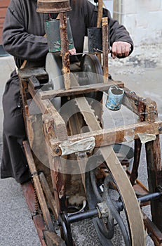 Grinder with large hands sharpen a blade of a knife