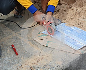 Grinder worker cuts a stone the electric tool worker is tiling a
