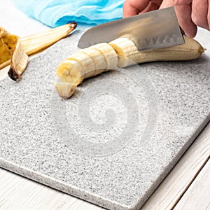 Grinding a banana on a cutting board made of artificial stone