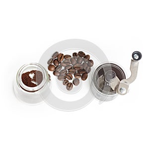 Grinding coffee beans in a manual coffee grinder over white background