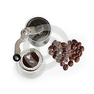 Grinding coffee beans in a manual coffee grinder over white background.