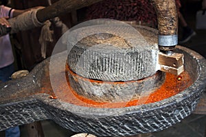 Grinding Dried Red Chillies in a stone Mill.