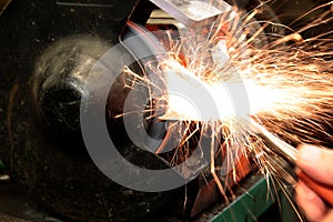 Grinding metal with a grinder in a workshop